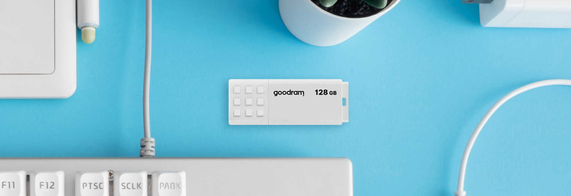 White USB UME on blue background with various computer accessories